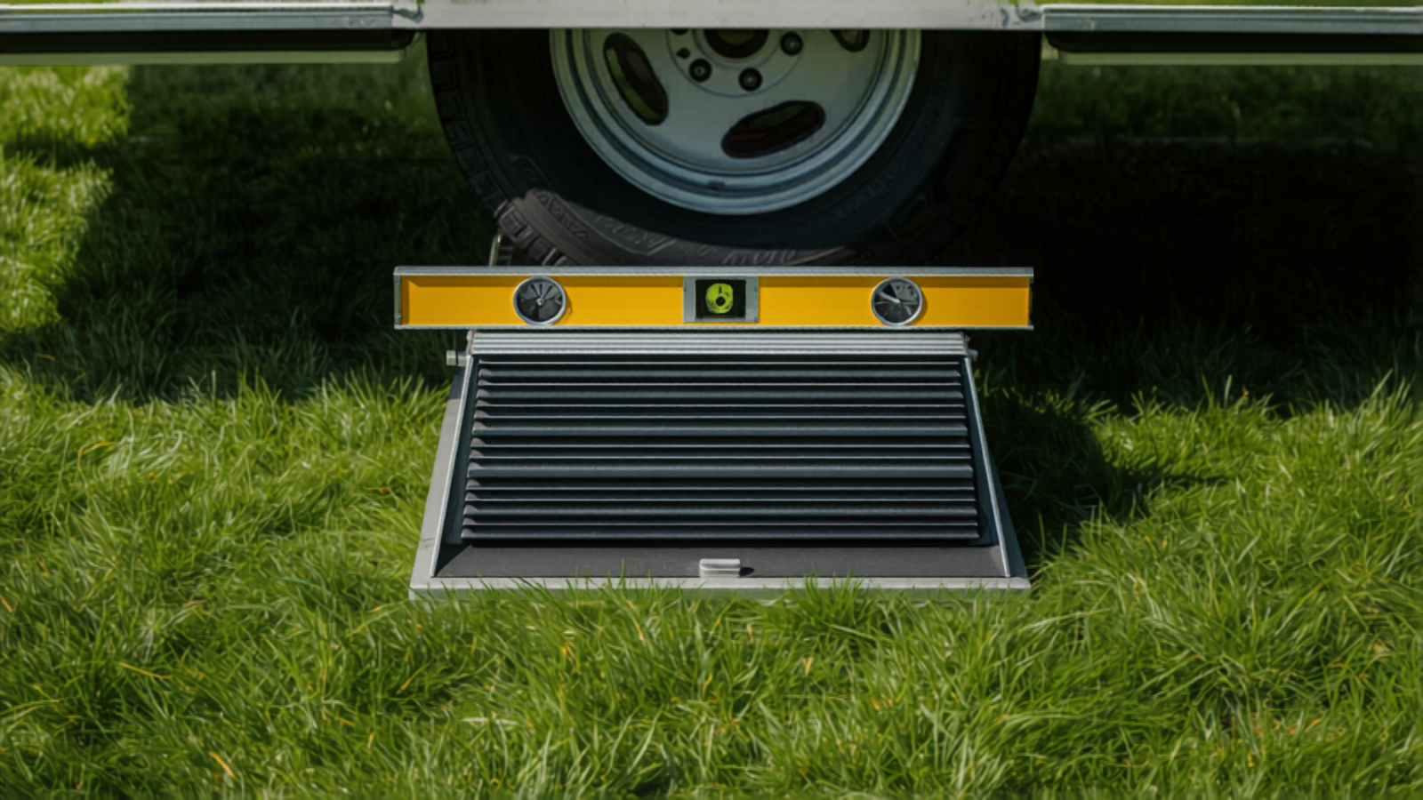 Wohnwagen auf Auffahrkeil mit Wasserwaage zum Nivellieren